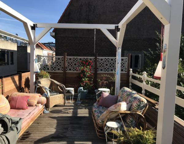 "Heerlijk op mijn dak in het oktober zonnetje! De omheining en de pergola maken het terras tot een heerlijk beschut paradijsje midden in de stad!"